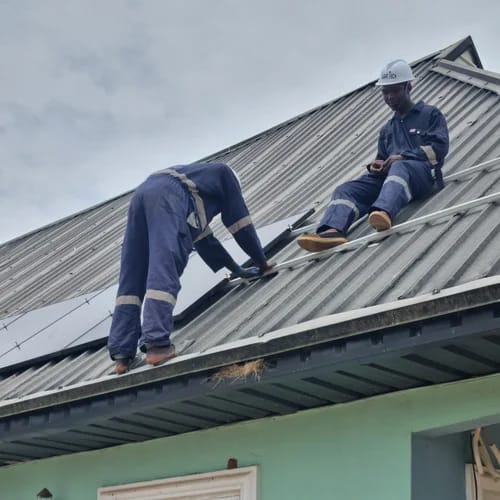 Image showing Engineers at work installing solar panels on a residential roof in Benin city.